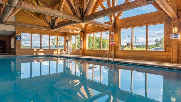 A wooden cabin with a pool, large windows, and a view of the outdoors. - Grand Ely Lodge Resort & Conference Center (Ely)