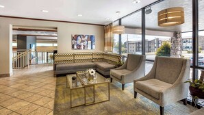 A lobby with a sofa, armchairs, a coffee table, and a large window offering a view of the outside. - Best Western Plus Landing View Inn & Suites (Branson)