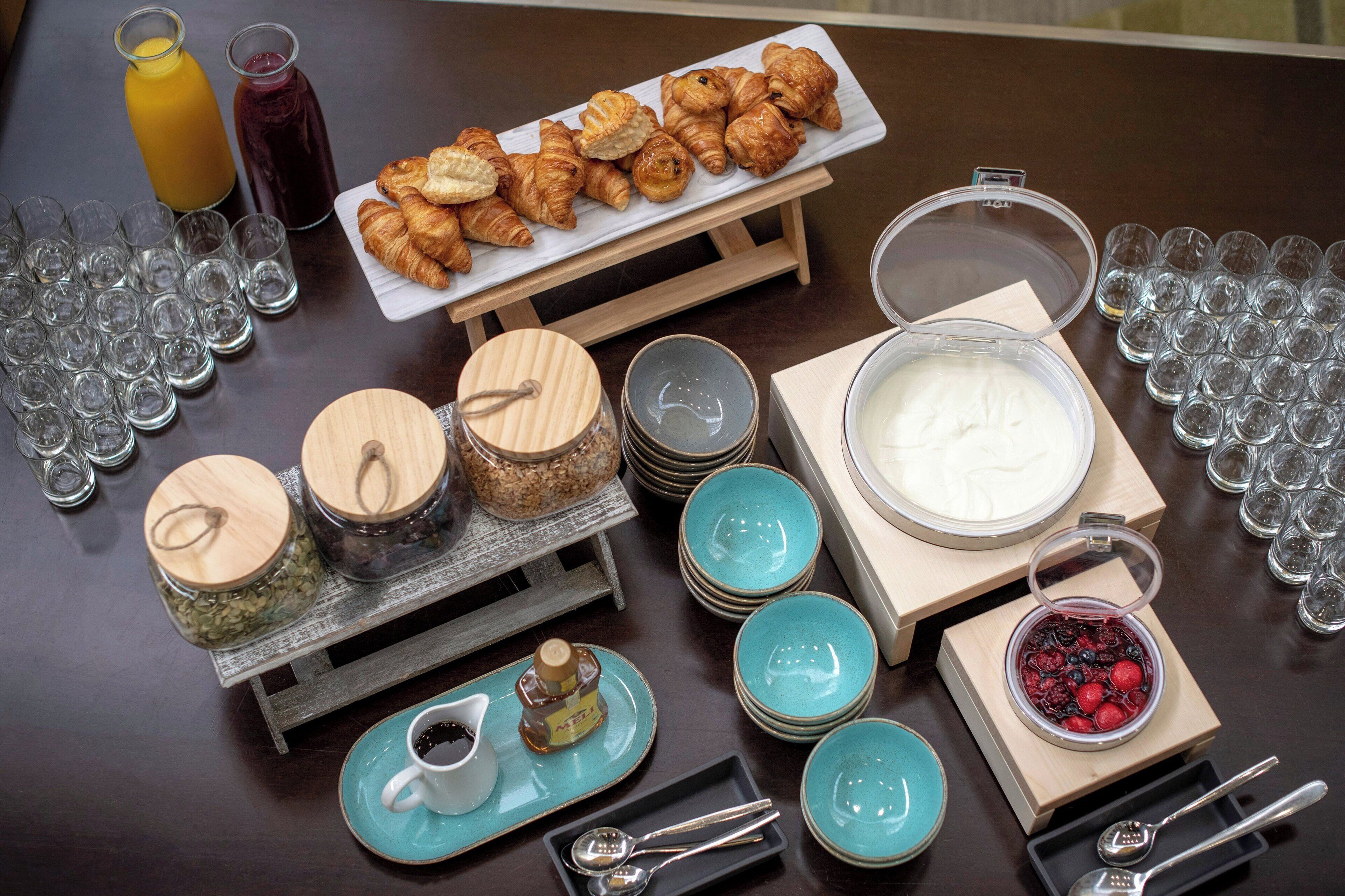 A breakfast buffet with croissants, fruit, and beverages.