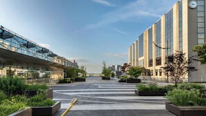 A modern building with large windows and a clock on the side. - Sheraton Brussels Airport Hotel (Zaventem)