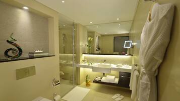 A modern bathroom with a glass shower enclosure, a white sink, and a mirror above the vanity.