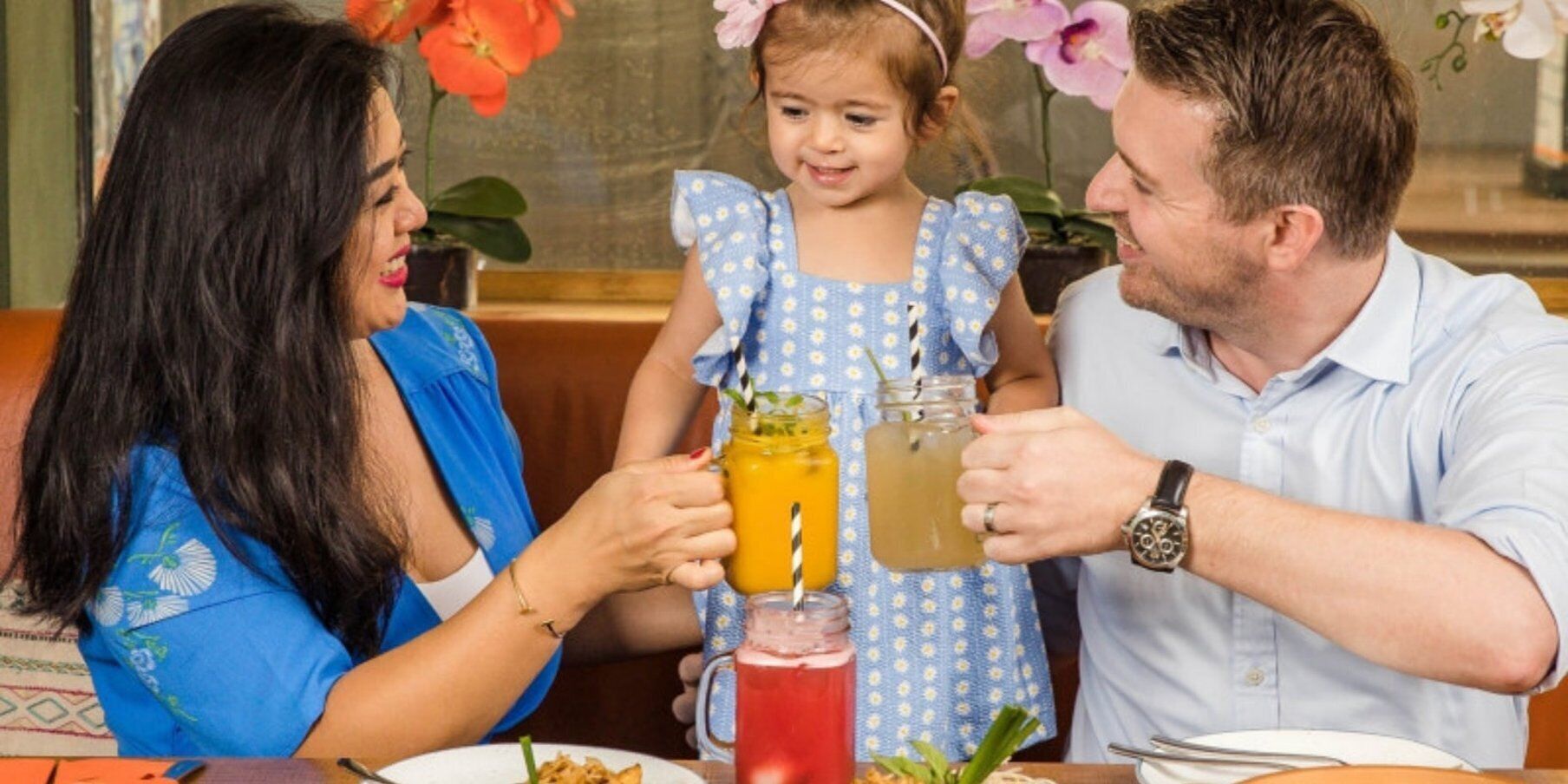 Una família dinant en un restaurant amb taula posta per a un àpat.