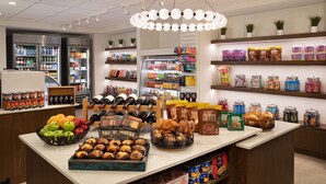 A bakery display with various baked goods and a selection of beverages.