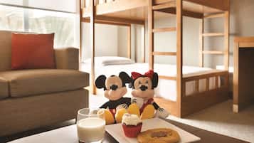 Cozy hotel room with a bunk bed, sofa, and table set, perfect for families.