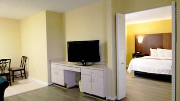 Una habitación de hotel con una cama, un televisor en un escritorio y una silla.