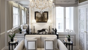 A spacious living room with a large sofa, a chandelier, and a fruit bowl on the coffee table. - Hotel Sacher Salzburg (Salzburg)