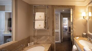 Ein modernes Badezimmer mit einer großen Badewanne, einem Waschtisch und einem Handtuchhalter mit zwei Handtüchern.