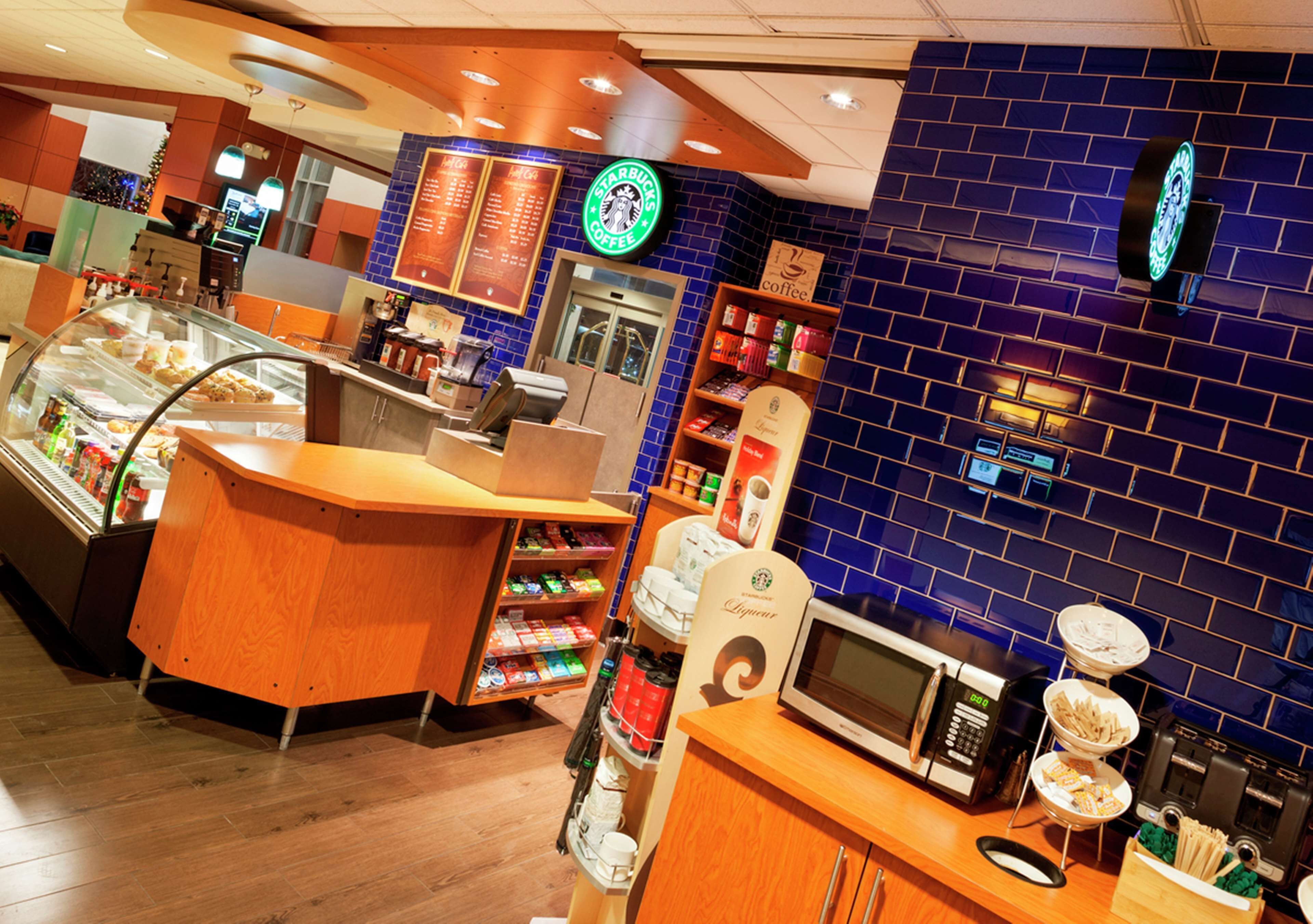 Un interior de cafetería Starbucks con mostrador, vitrinas y zona de estar.