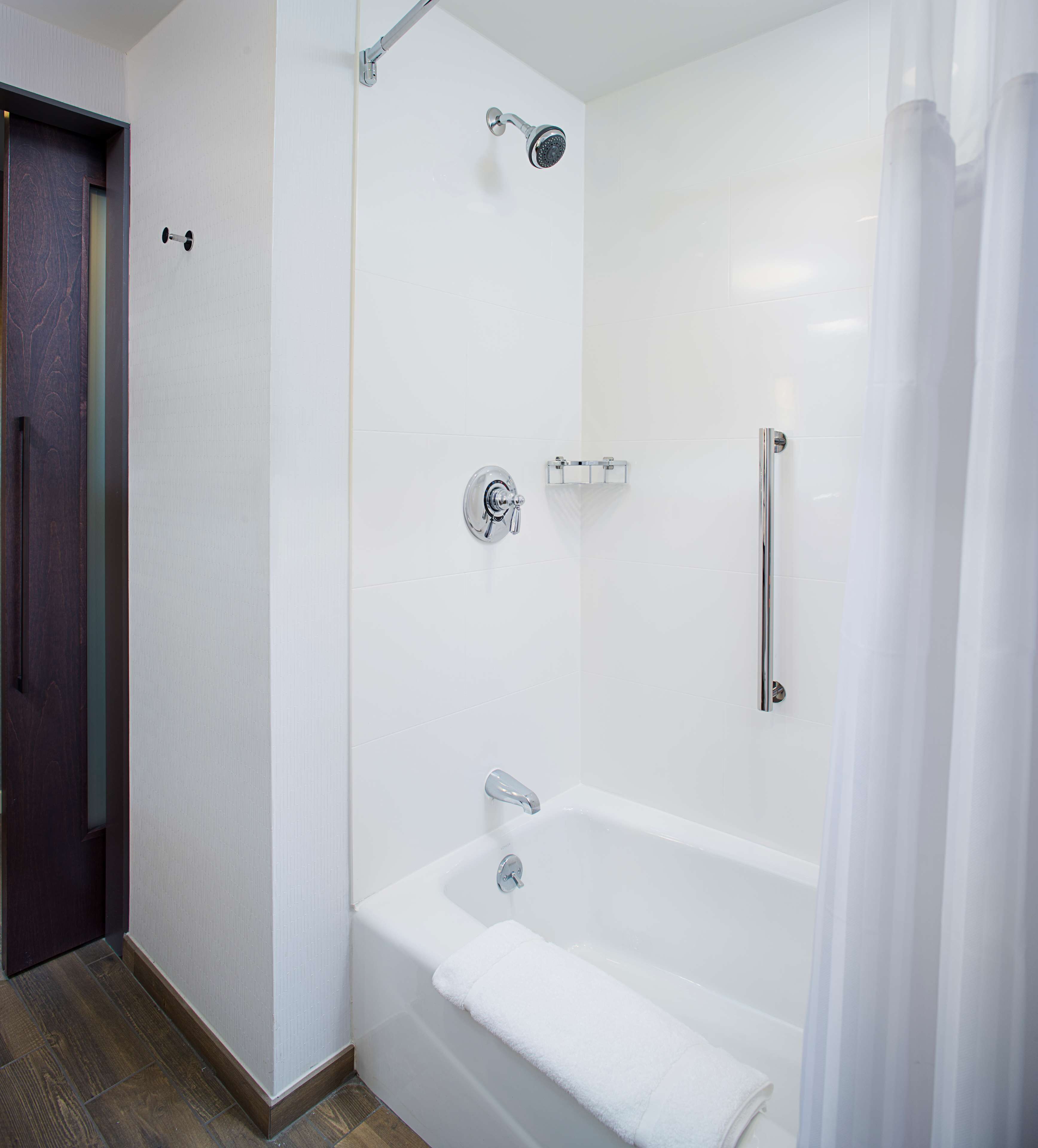Un baño moderno con ducha a ras de suelo, bañera y retrete.