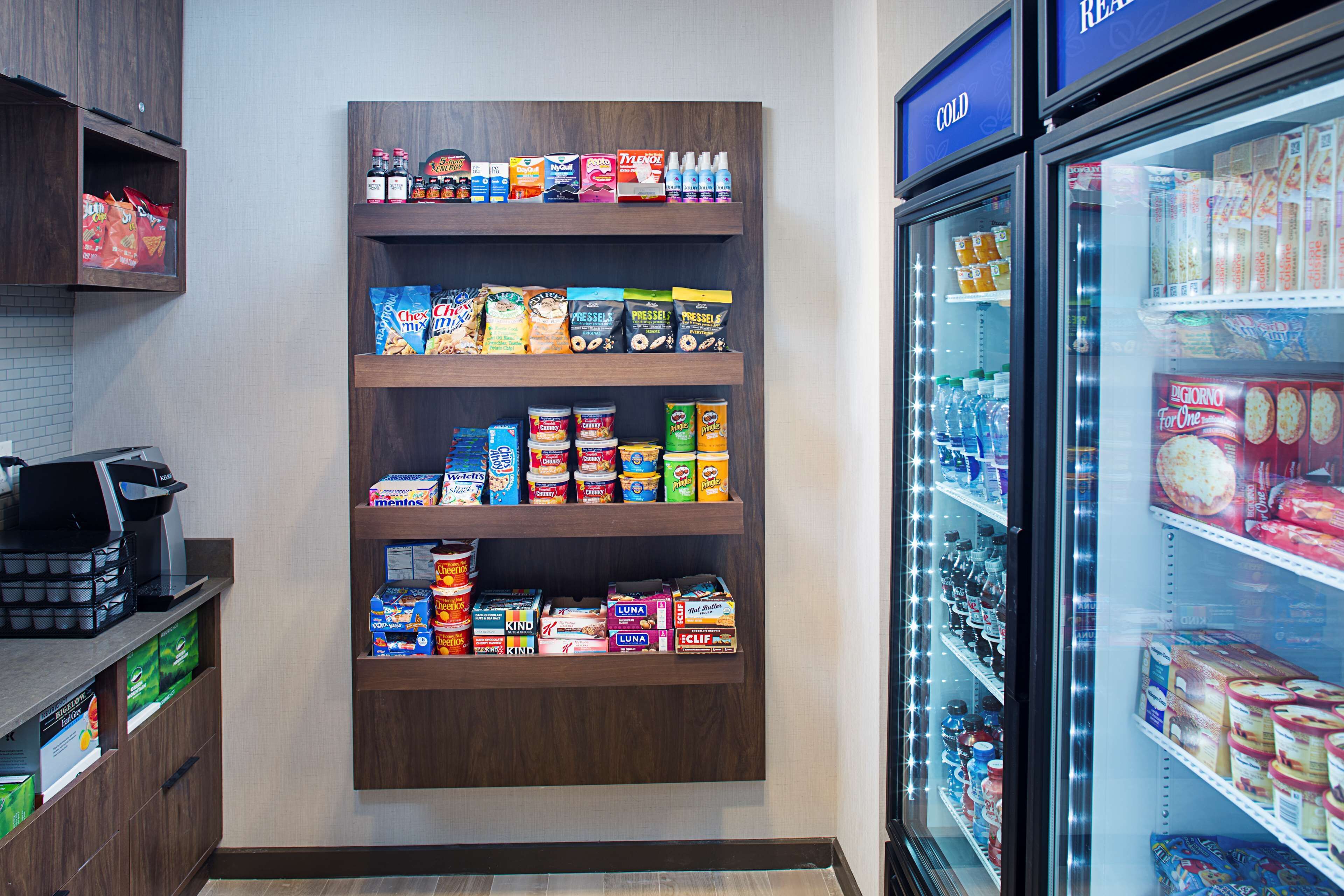 Un supermercado con estantes llenos de snacks, bebidas y productos refrigerados.