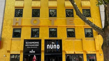 Um edifício amarelo com várias janelas e uma placa com a inscrição 'HOTE'.