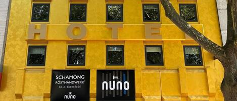 Un edificio amarillo con varias ventanas y un letrero que dice 'HOTE'.