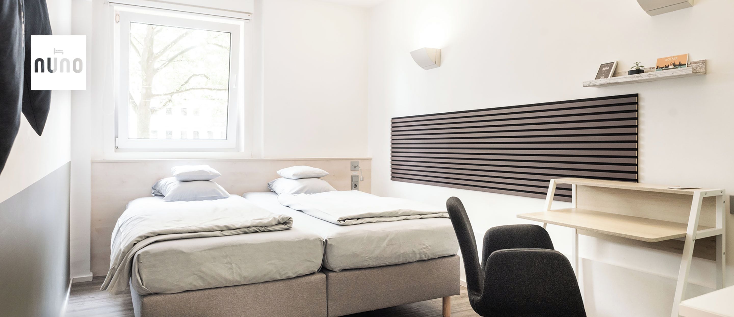 A medium-sized room with a bed, a desk, and a chair.