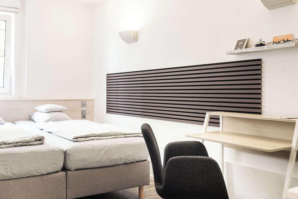 A medium-sized room with a bed, a desk, and a chair.