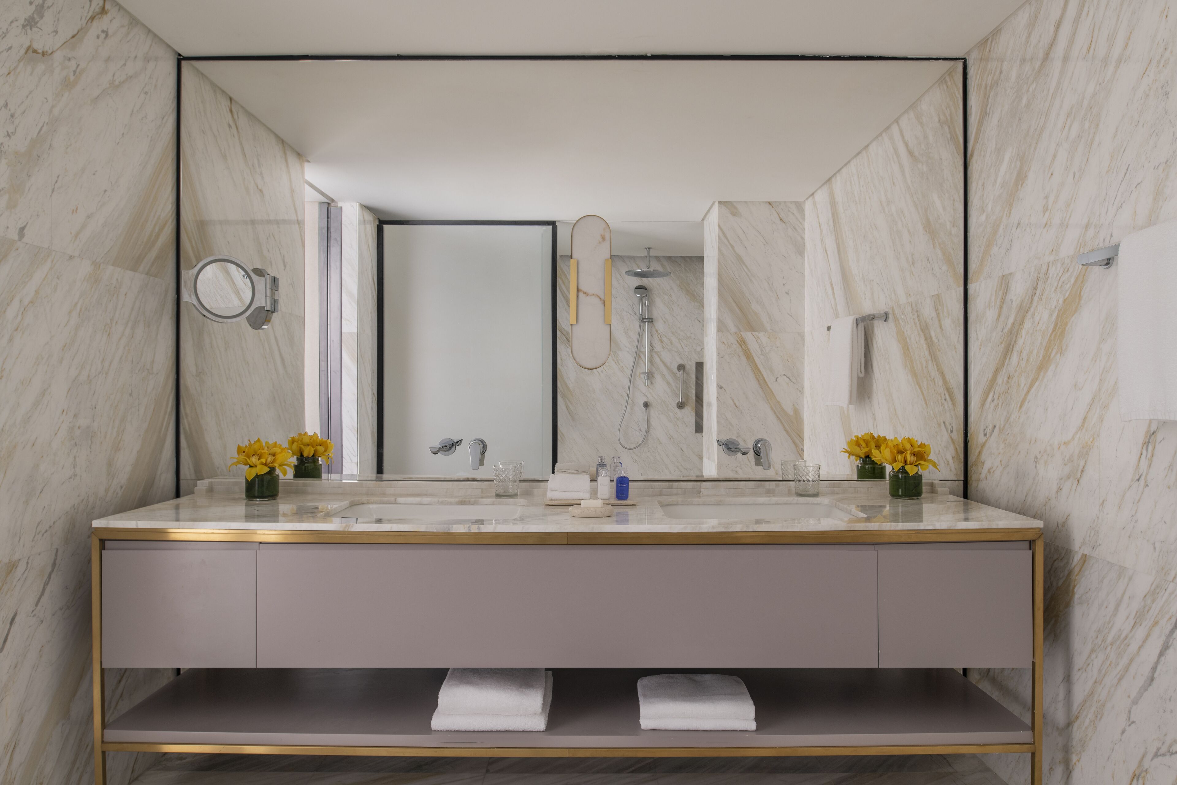 Une salle de bain moderne avec un meuble-lavabo en marbre, deux vasques, un grand miroir et une douche.