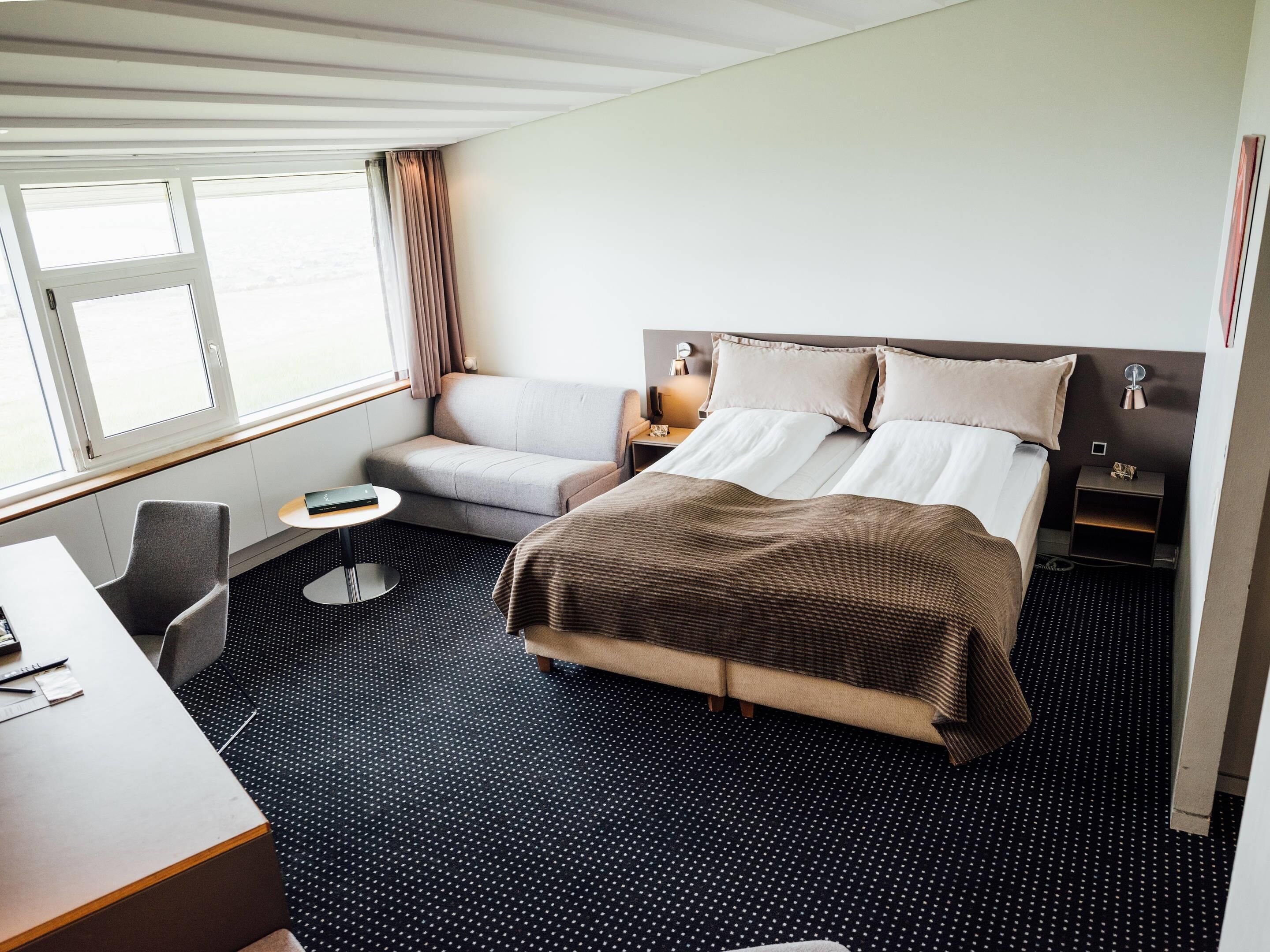 Una habitación de hotel con una cama, un sofá, un escritorio y una silla.