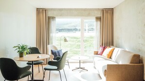 A modern living room with a sofa, chairs, a small table, and a plant. - Hotel Føroyar (Tórshavn)