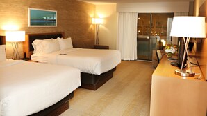 A hotel room with two beds, a desk, and a large window with curtains. - enVision Hotel & Conference Center Mansfield-Foxboro (Mansfield)