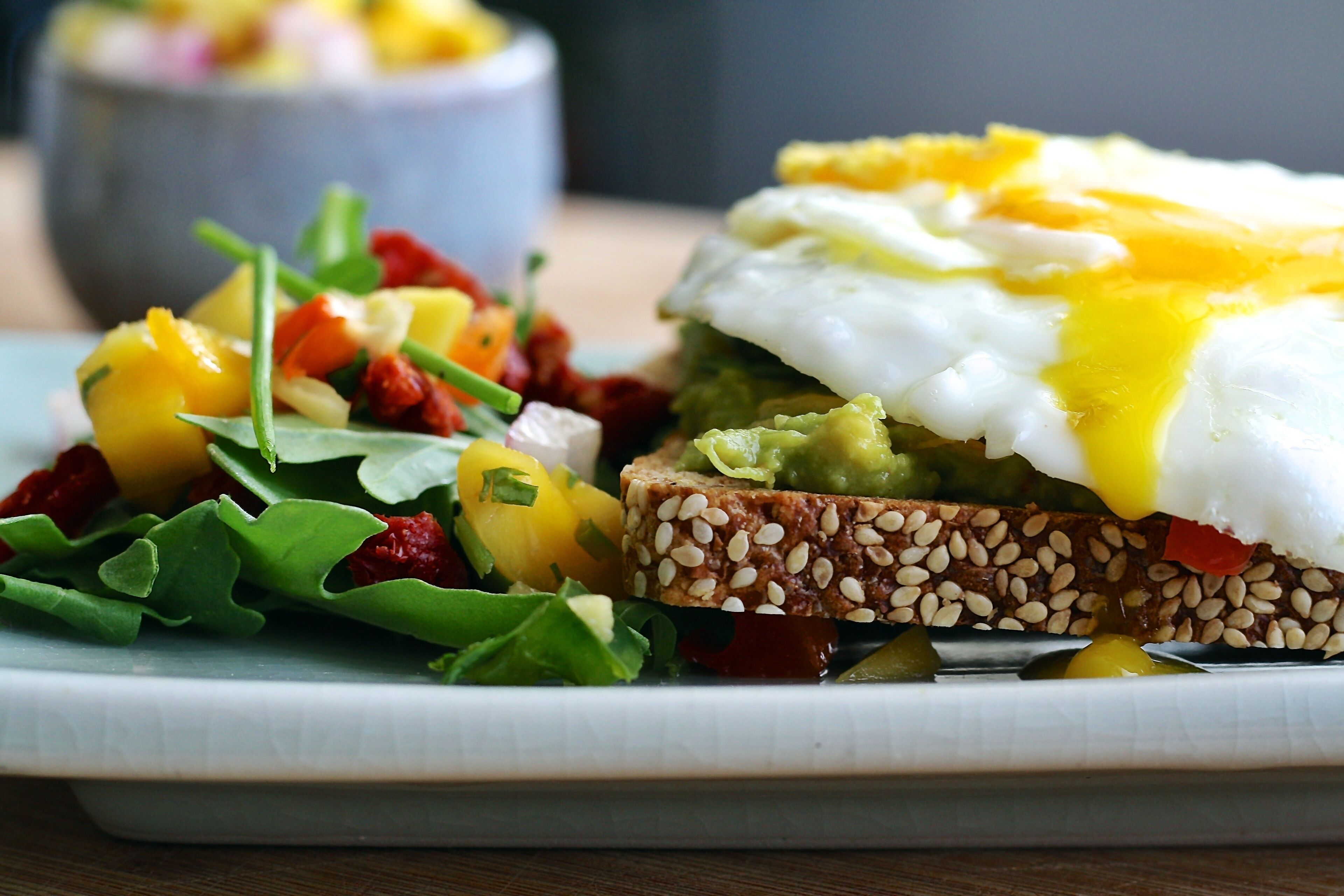 A plate with a sandwich, a poached egg, and a side salad.