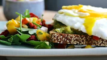 A plate with a sandwich, a poached egg, and a side salad.