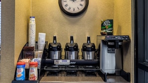 Eine Kaffeestation mit einer Uhr, Kaffeeautomaten und einem Nescafe-Spender.