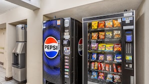 Un distributeur automatique aux couleurs de Pepsi et un autre distributeur proposant une variété d’en-cas.