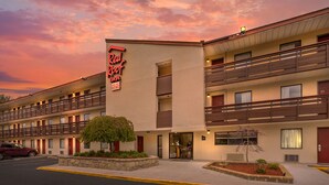 A Red Roof Inn with a two-story structure, a balcony on the upper level, and a small tree in the front. - Red Roof Inn Tinton Falls - Jersey Shore (Tinton Falls)