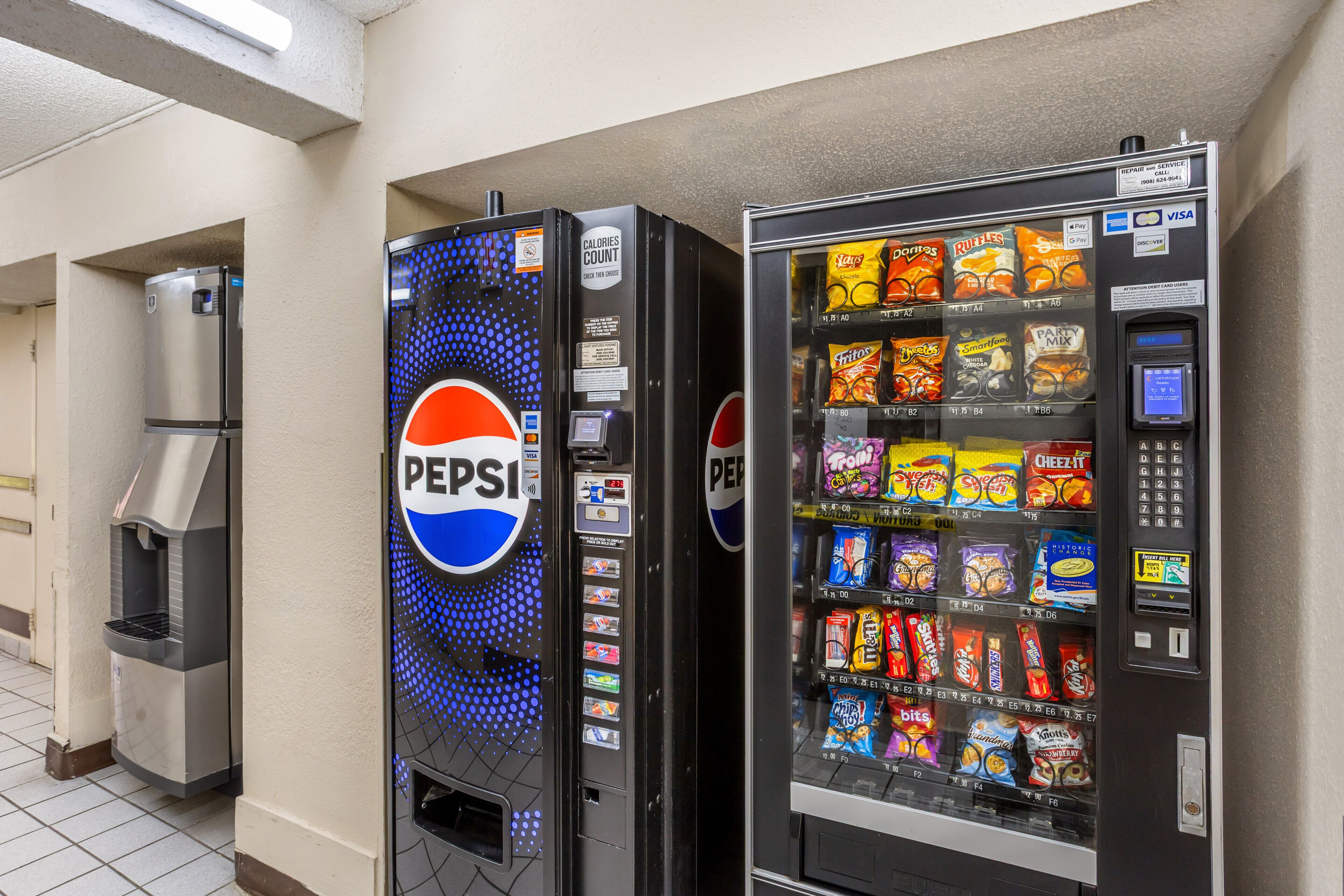 Dos máquinas expendedoras, una de Pepsi y otra con diversos bocadillos.