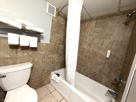 Un baño con inodoro, bañera y ducha.