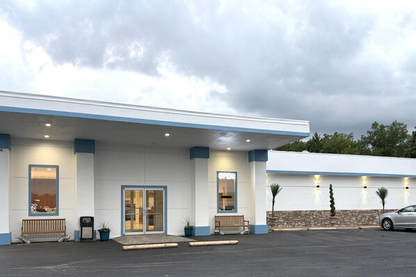 A building with a flat roof, a front entrance, and a parking lot.