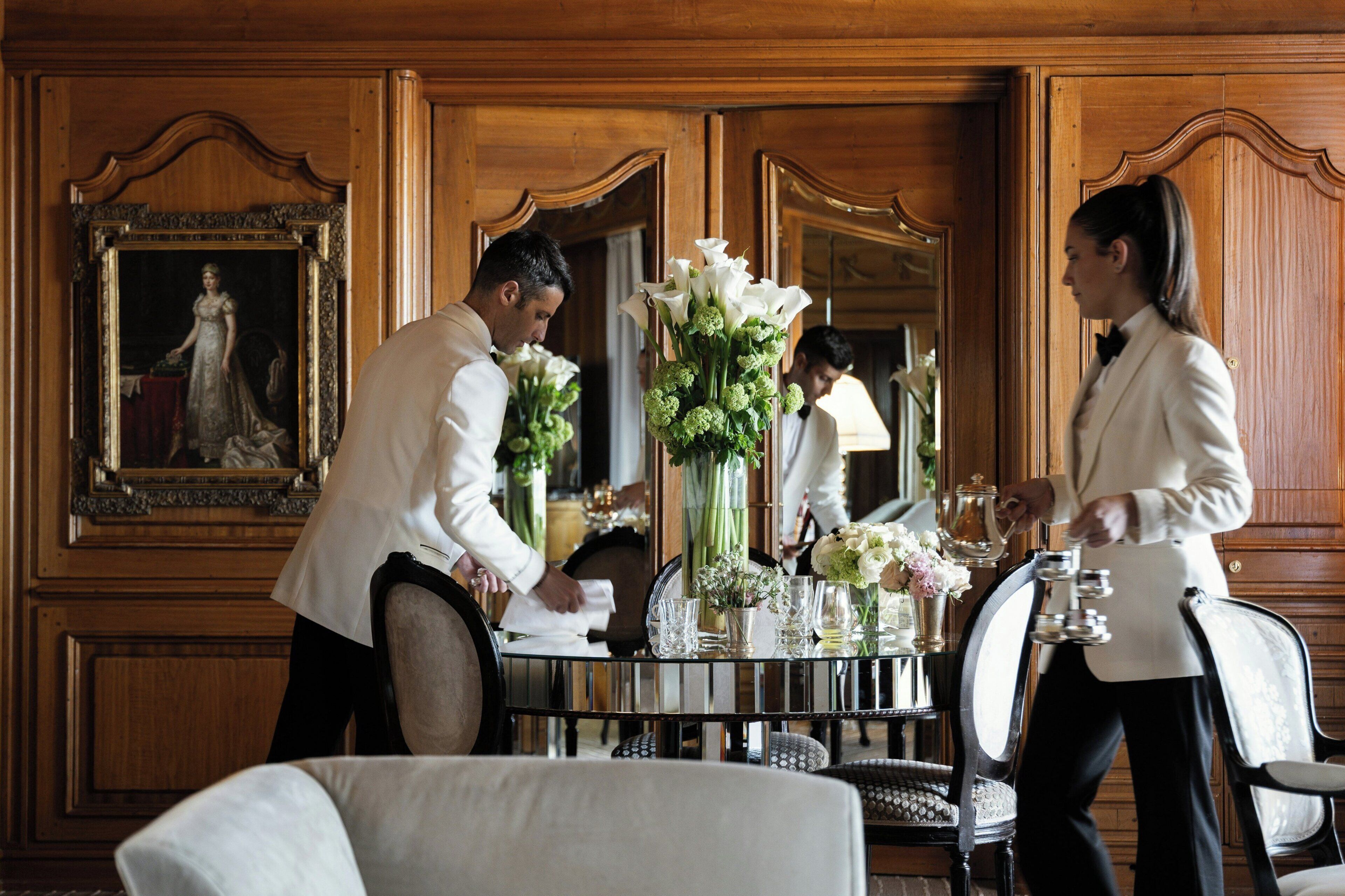 Un comedor formal con una mesa de madera pulida, sillas elegantes y un espejo grande que refleja la estancia.