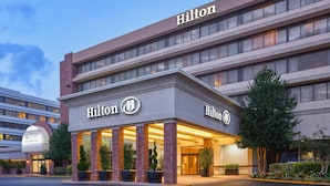 A Hilton hotel with a modern facade, large windows, and a well-lit entrance. - Hilton Washington DC/Rockville Hotel & Executive Meeting Ctr (Rockville)