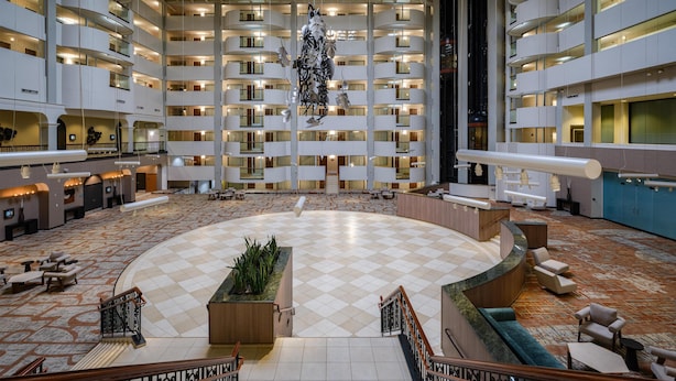 A spacious lobby with a checkered floor, a central seating area, and a staircase leading to upper floors. - Hilton Washington DC/Rockville Hotel & Executive Meeting Ctr (Rockville)