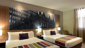 A hotel room with two beds, a large cityscape painting on the wall, and a view of the city through the window. - Grosvenor Hotel Adelaide by Accor (Adelaide)