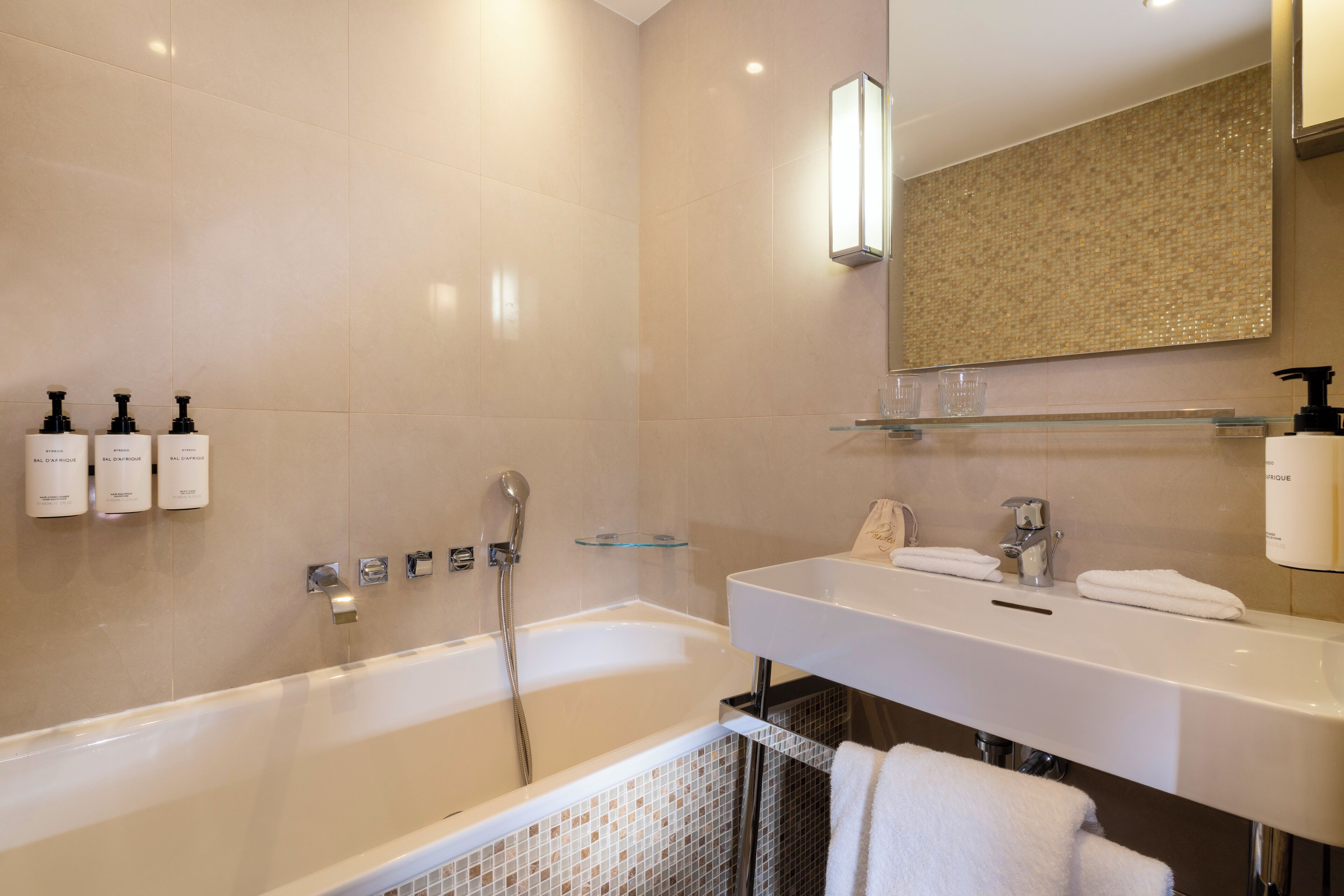 A modern bathroom with a bathtub, a sink, and a mirror.