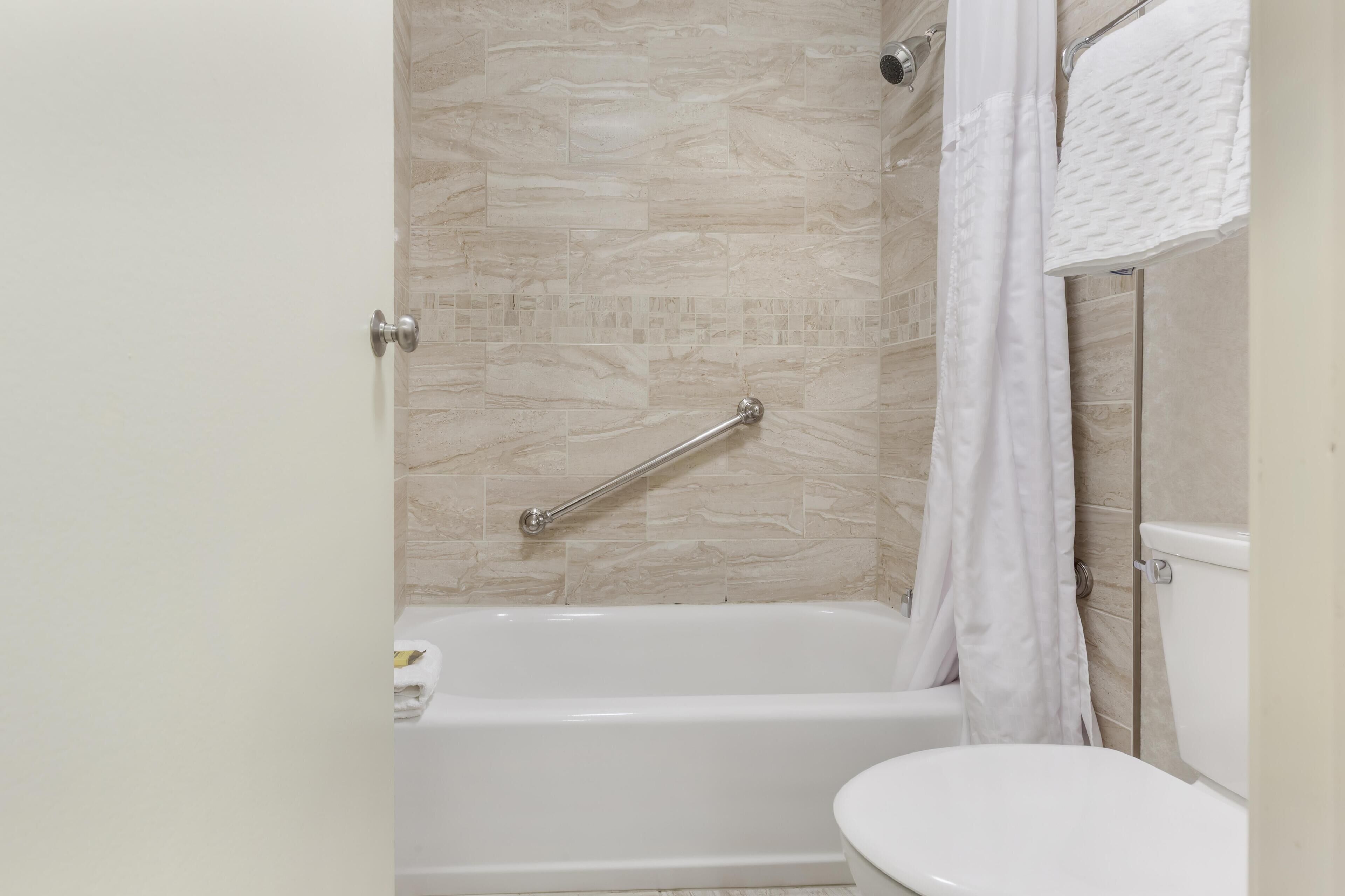 Ein Badezimmer mit Badewanne, Toilette und Duschvorhang.