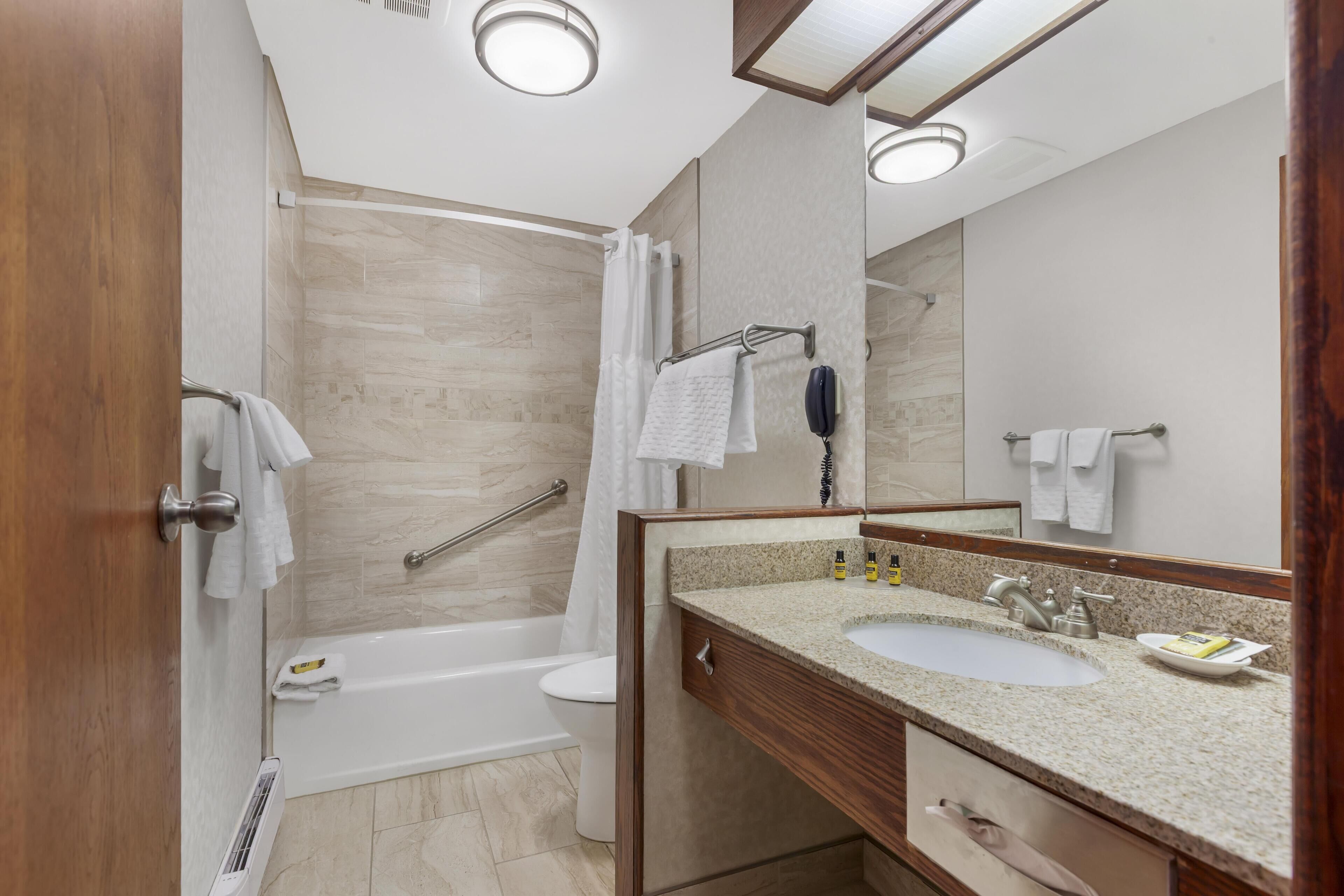 A modern bathroom with a bathtub, toilet, and sink.