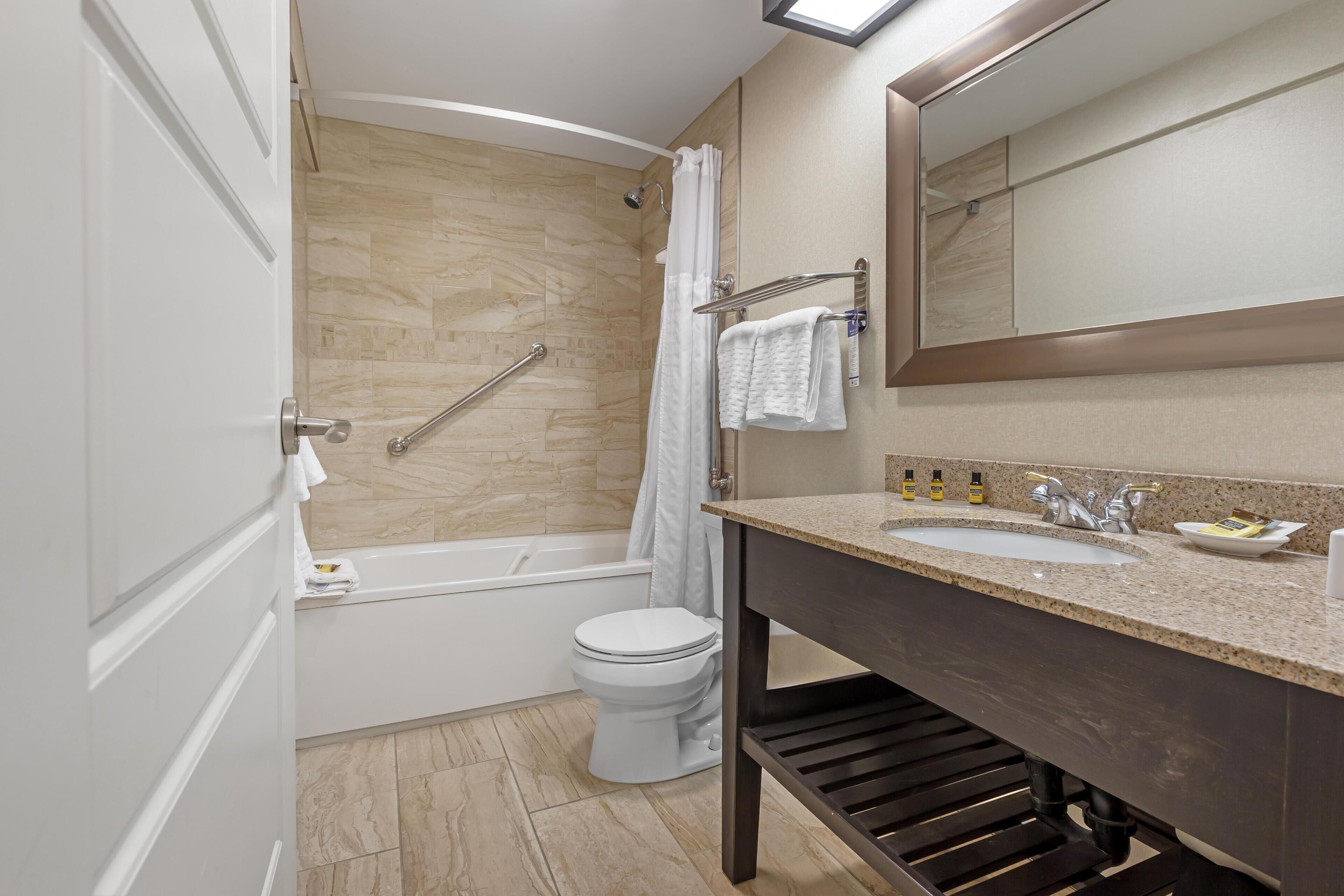 Ein modernes Badezimmer mit Badewanne, Toilette und Waschbecken.