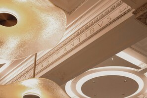 A ceiling with decorative moldings and a circular light fixture.