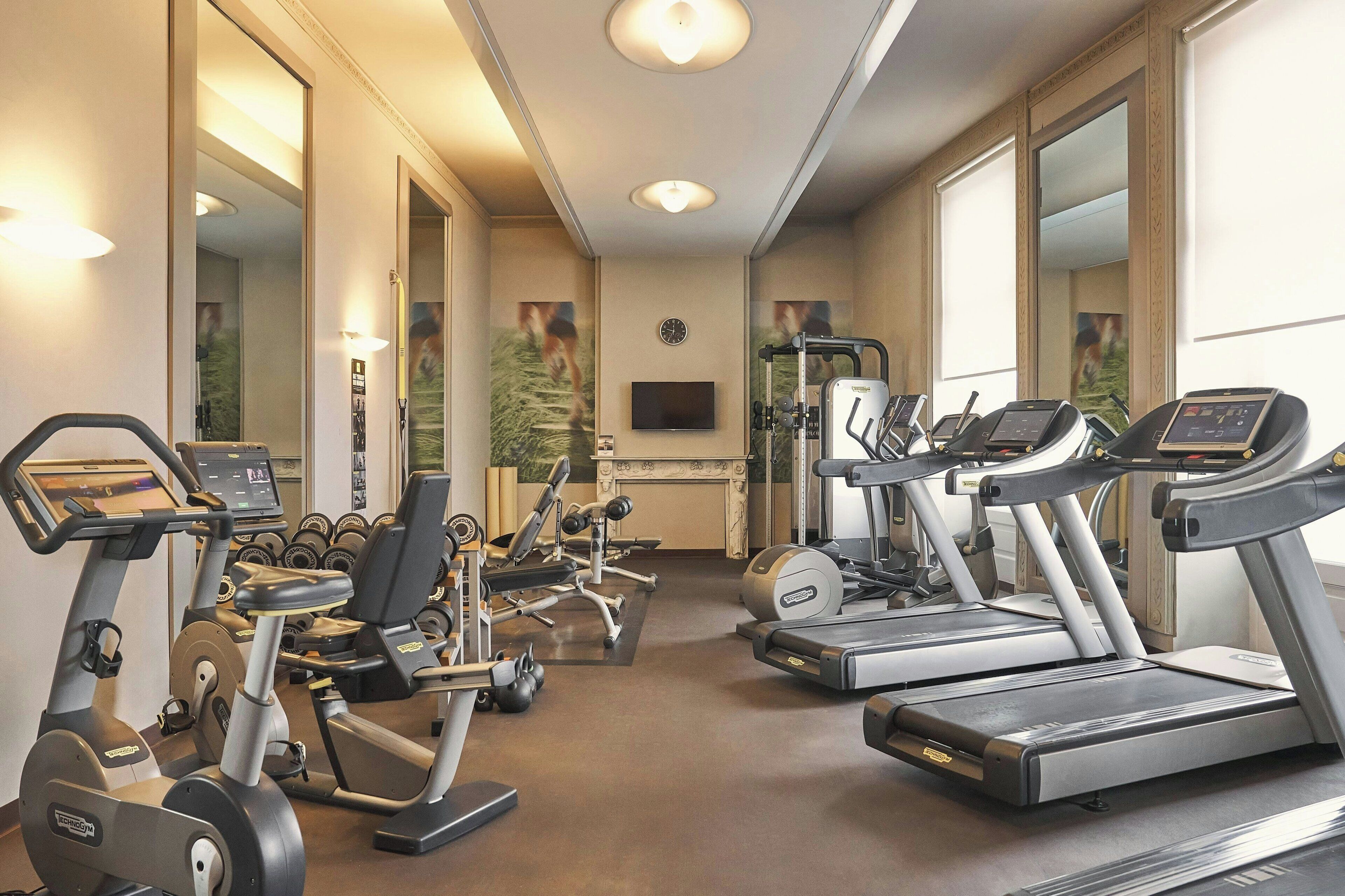 A gym with treadmills, elliptical machines, and weight equipment.