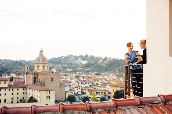 Enjoy breathtaking views of the historic town from this balcony, featuring a metal railing and a window overlooking the town's architecture and streets.