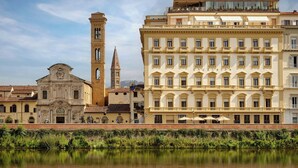A historic building with a bell tower and a modern building with balconies and windows. - The Excelsior, a Luxury Collection Hotel, Florence (Florence)