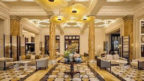 A luxurious lobby with marble flooring, elegant furniture, and a central decorative table with floral arrangements. - The Excelsior, a Luxury Collection Hotel, Florence (Florence)
