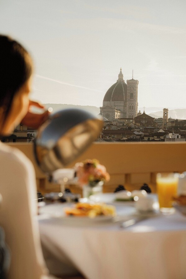A dining table with a view of a historic building in the background.