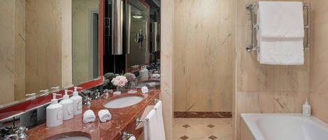 Un baño moderno con dos lavamanos, un espejo grande, una bañera y una zona de ducha.