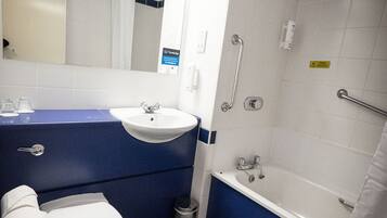 A bathroom with a white sink, a toilet, and a shower area.