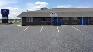 A Best Value Inn with a parking lot, a sign for free Wi-Fi and breakfast, and a clear blue sky. - Americas Best Value Inn Sullivan (Sullivan)