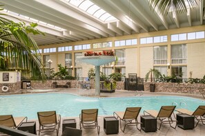 An indoor swimming pool with lounge chairs and a water fountain. - Wyndham Garden Fresno Yosemite Airport (Fresno)