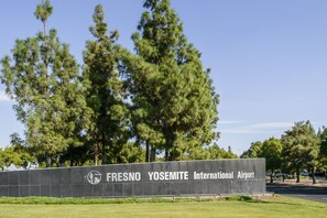 A sign for Fresno Yosemite International Airport with a clear sky and trees in the background. - Wyndham Garden Fresno Yosemite Airport (Fresno)