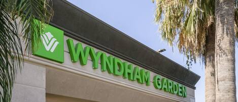 The Wyndham Garden hotel sign with a green logo and the name in white letters.